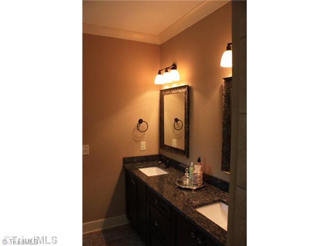 8906 West Pepper Court Oak Ridge, NC 27310 - Photo 12 of 16 Master Bath/Spa. The master vanity, along with all tops in this home, are granite. Note the decorative mirrors, light fixtures, and awesome tile work.