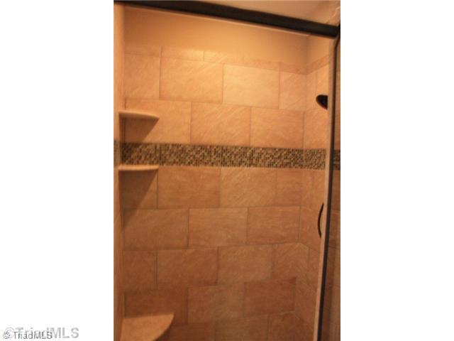 8906 West Pepper Court Oak Ridge, NC 27310 - Photo 13 of 16 Master Bath/Spa. The decorative tile work continues in the master shower.