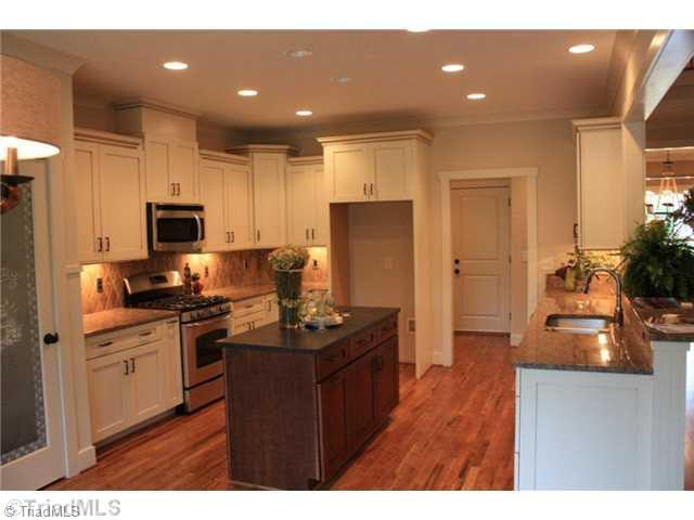 8906 West Pepper Court Oak Ridge, NC 27310 - Photo 3 of 16 Kitchen. The kitchen is open to the Great Room. There is an island with a honed leather finish granite top. Pantry has a decorative door.
