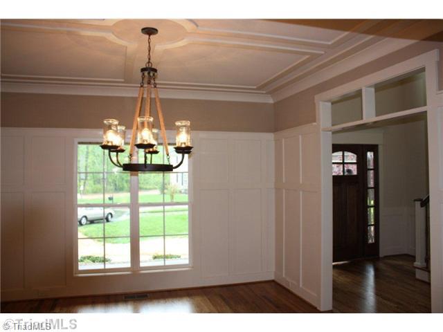8906 West Pepper Court Oak Ridge, NC 27310 - Photo 6 of 16 Dining Room. The Dining Room sports custom wainscoting with a plate rack. Notice the ceiling detail and transoms. The room is open to the Foyer and Great Room. Custom features abound in this Parade home!