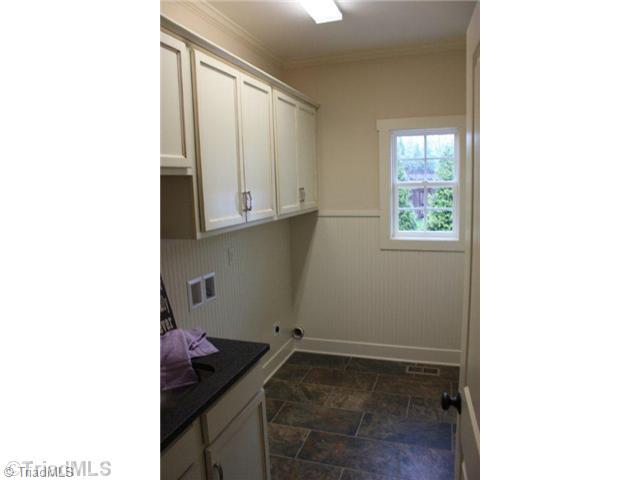 8906 West Pepper Court Oak Ridge, NC 27310 - Photo 8 of 16 Laundry Room. The laundry has lots of cabinets and a utility sink set in granite. There is also a closet located in this room for storing all of those household cleaning products. The window provides some much appreciated natural light. Such a well-planned work space.