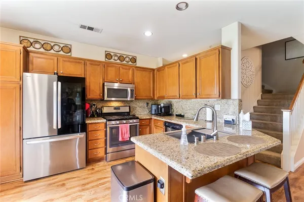 a kitchen with granite countertop a sink refrigerator and microwave