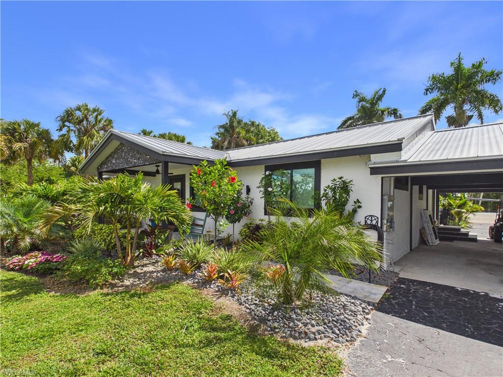 3650 Sunset Boulevard Naples, FL 34112 - Photo 1 of 37 a front view of a house with garden