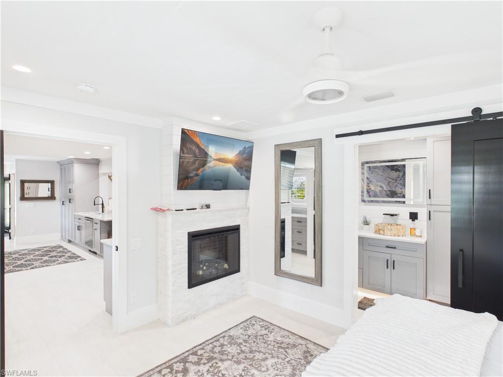 3650 Sunset Boulevard Naples, FL 34112 - Photo 12 of 37 a bedroom with a bed and a fireplace