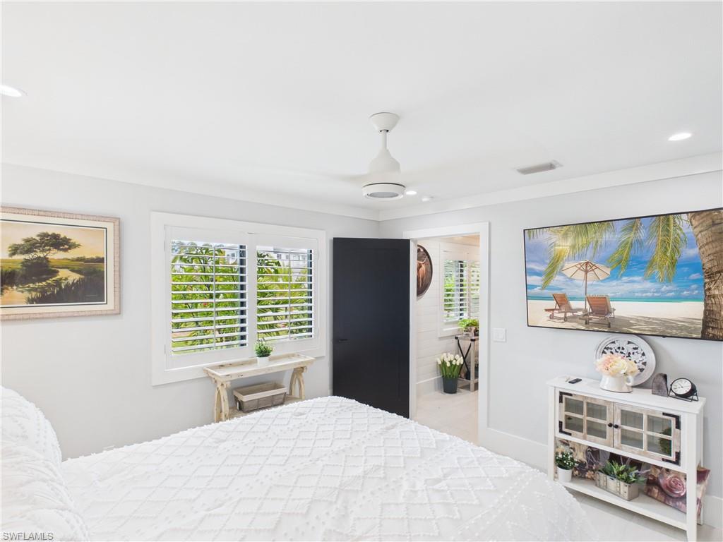 3650 Sunset Boulevard Naples, FL 34112 - Photo 26 of 37 a bedroom with a bed and a flat tv screen on dresser