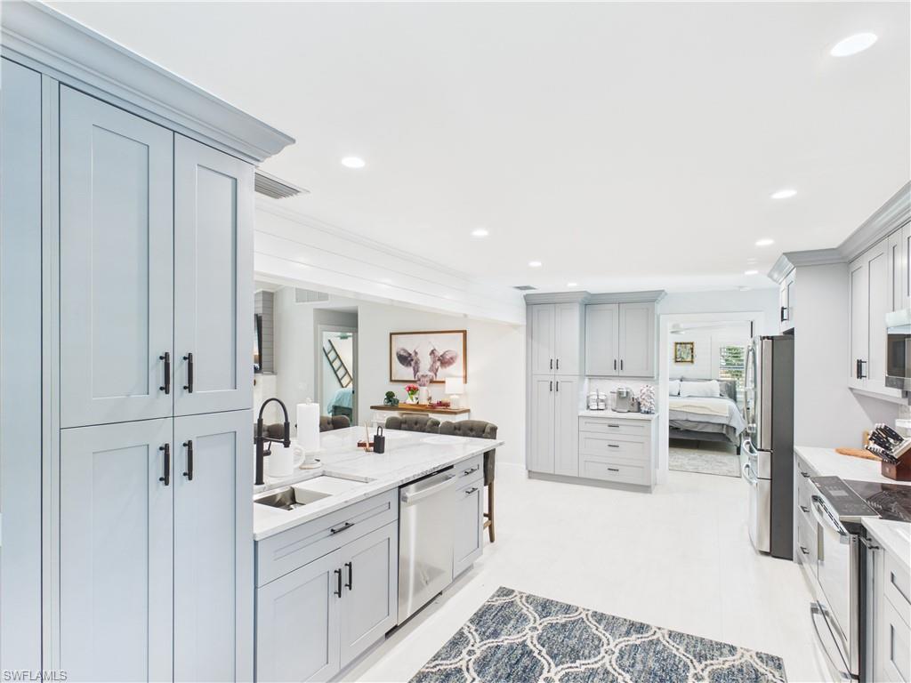 3650 Sunset Boulevard Naples, FL 34112 - Photo 6 of 37 a kitchen with stainless steel appliances a sink stove and cabinets