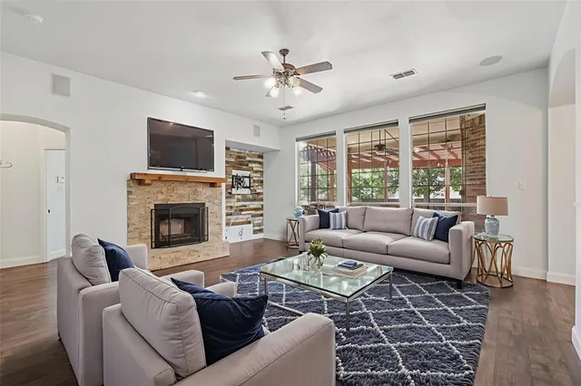 a living room with furniture a large window and a fireplace