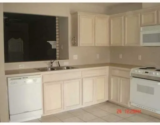 a kitchen with white cabinets and sink