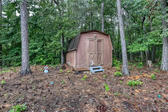 a view of a tiny house with yard and trees