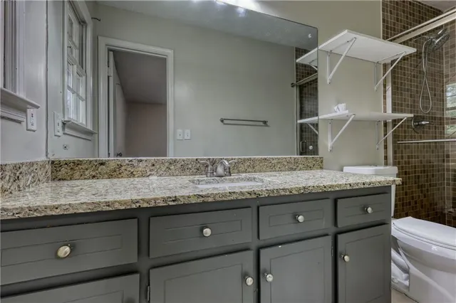 a bathroom with a granite countertop sink and a mirror