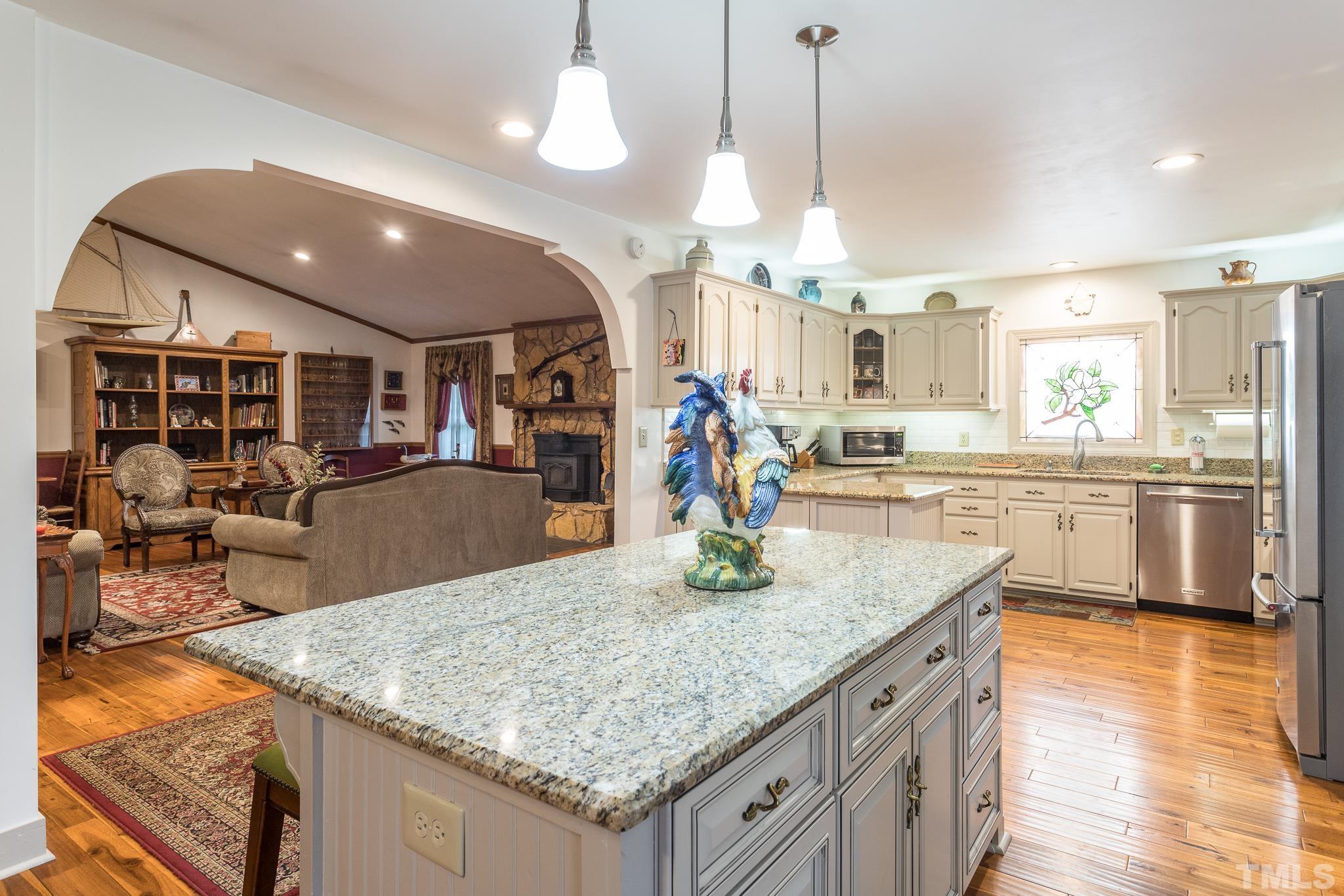 3021 Peebles Road Raleigh, NC 27616 - Photo 16 of 45 a kitchen with stainless steel appliances granite countertop a sink counter space and wooden floor