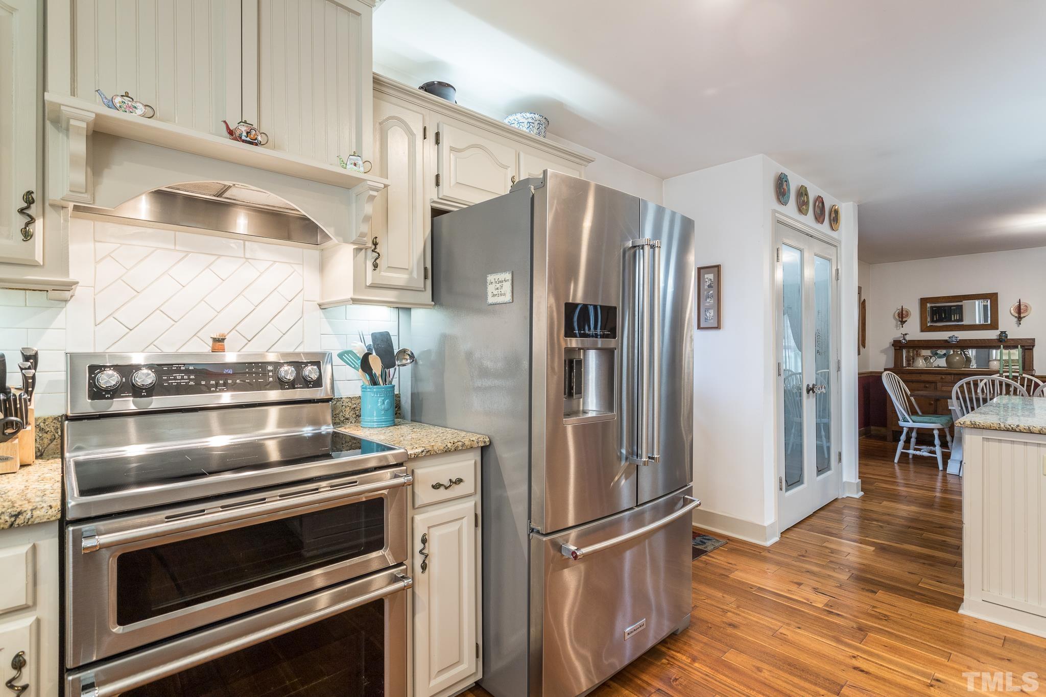 3021 Peebles Road Raleigh, NC 27616 - Photo 18 of 45 a kitchen with stainless steel appliances and wooden floor