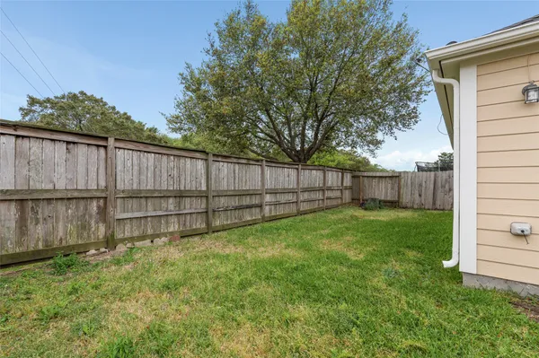 a view of a backyard with wooden fence