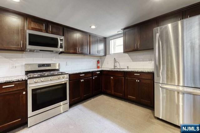 407 Hudson Street, Unit 1 Hackensack, NJ 07601 - Photo 4 of 8 a kitchen with stainless steel appliances granite countertop a stove microwave and refrigerator