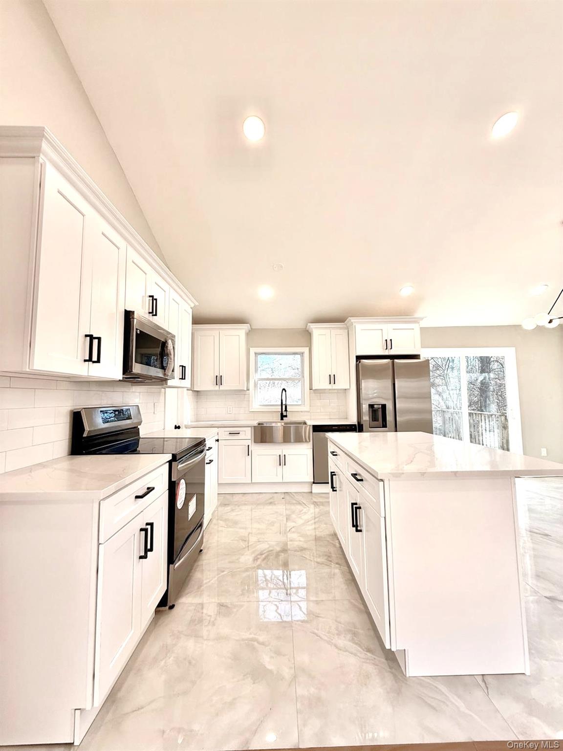 53 West Yaphank Road Medford, NY 11763 - Photo 4 of 24 a large white open kitchen with stainless steel appliances kitchen island granite countertop a sink and white cabinets