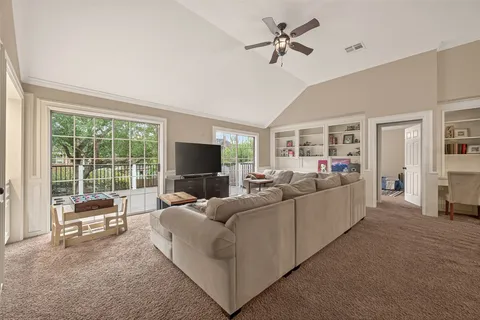 a living room with furniture a flat screen tv and a large window