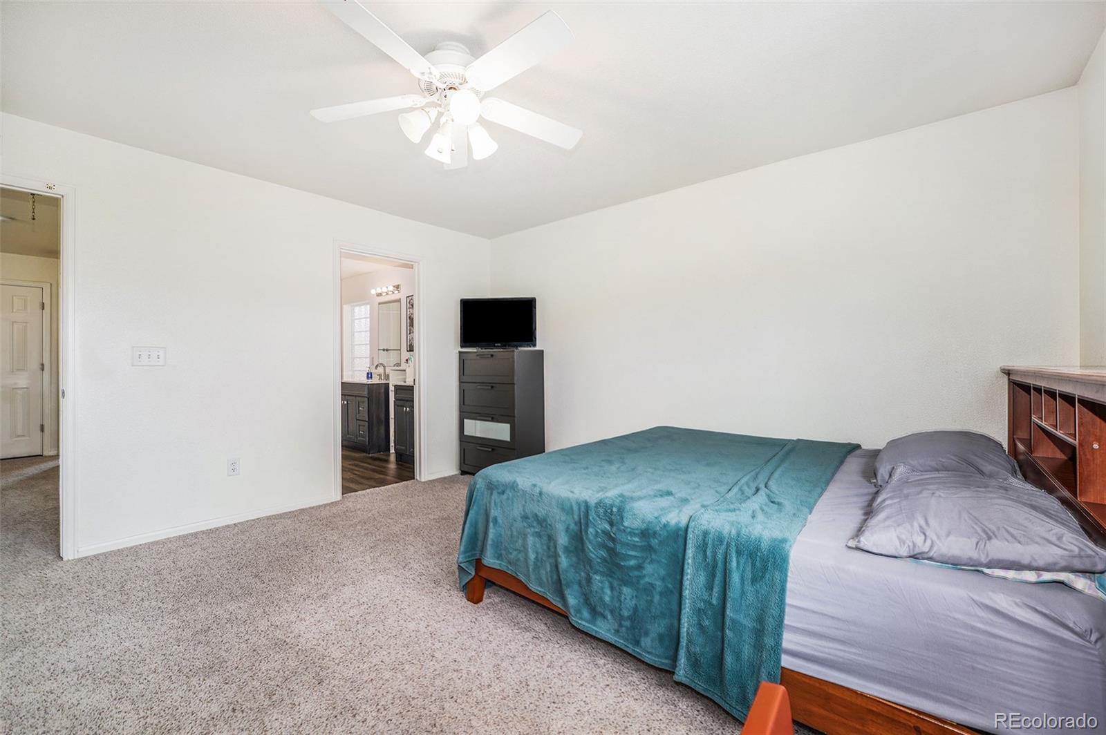 1822 Coach House Loop Castle Rock, CO 80109 - Photo 19 of 35 a bedroom with a bed and a ceiling fan