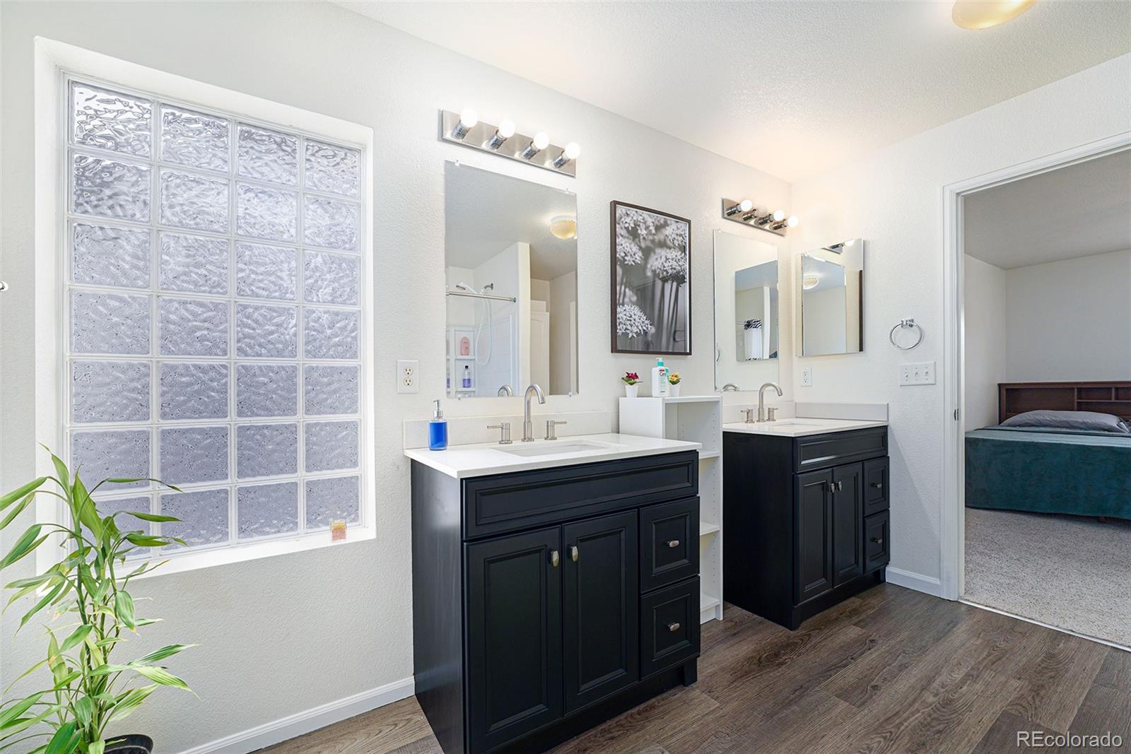 1822 Coach House Loop Castle Rock, CO 80109 - Photo 22 of 35 a spacious bathroom with a double vanity sink a and a large mirror