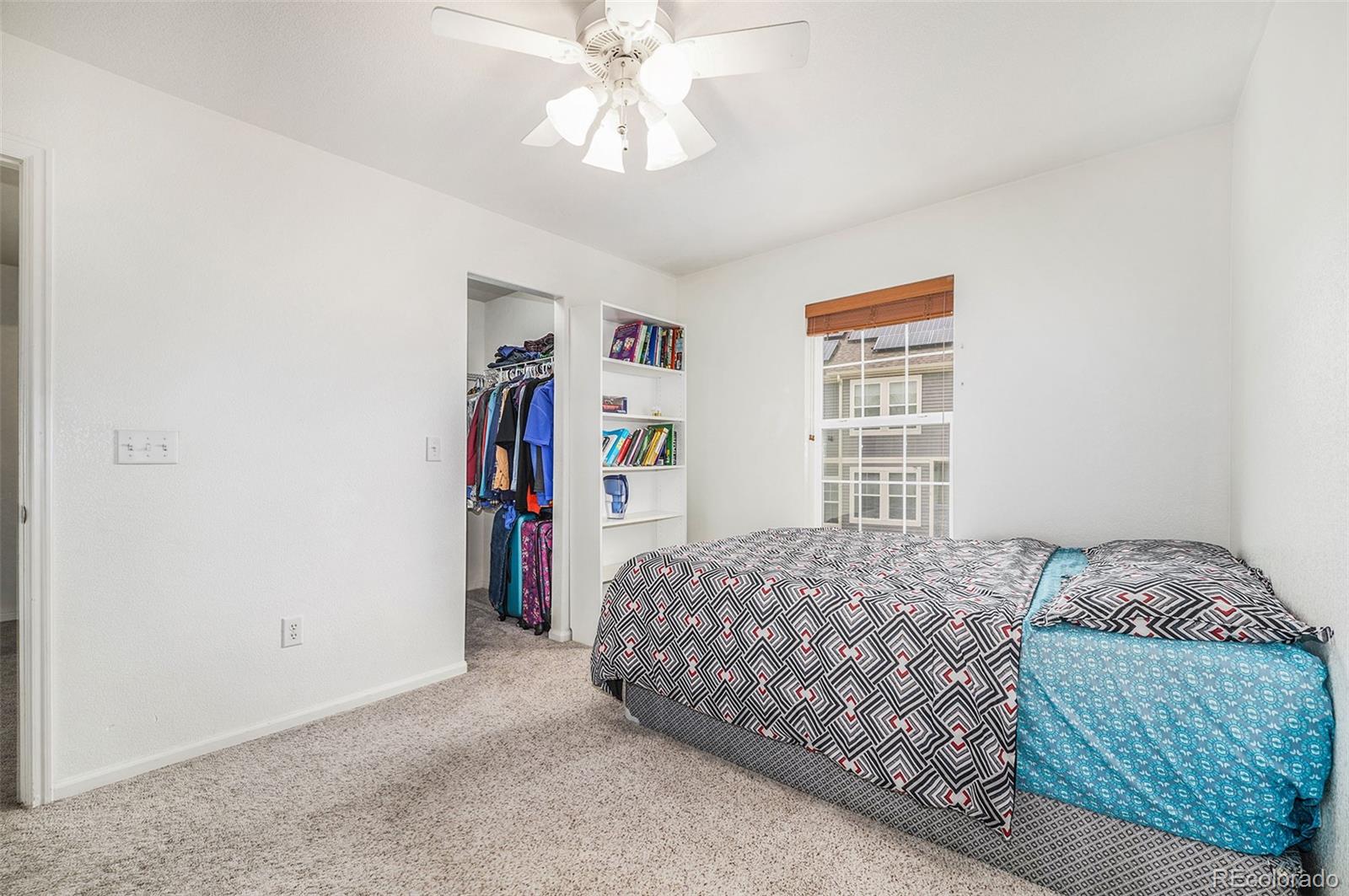 1822 Coach House Loop Castle Rock, CO 80109 - Photo 28 of 35 a bedroom with a large bed and a chandelier