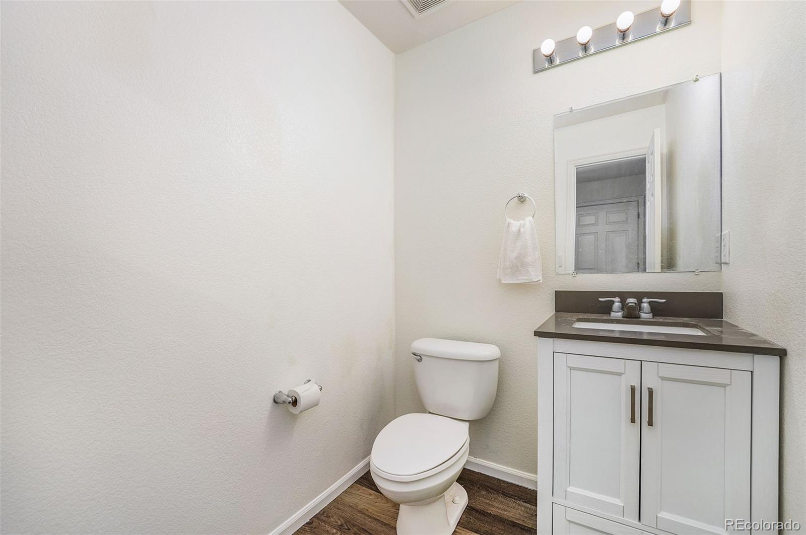 1822 Coach House Loop Castle Rock, CO 80109 - Photo 32 of 35 a bathroom with a granite countertop toilet and a sink