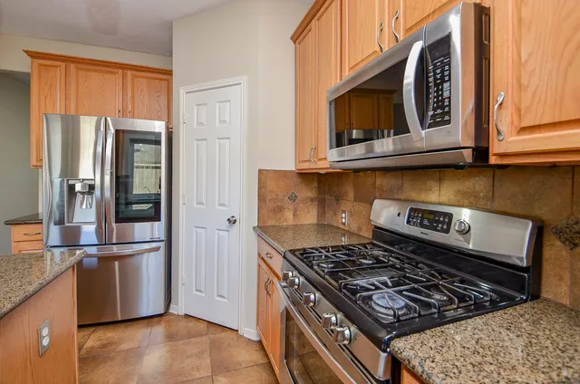 a kitchen with stainless steel appliances granite countertop a stove and a refrigerator