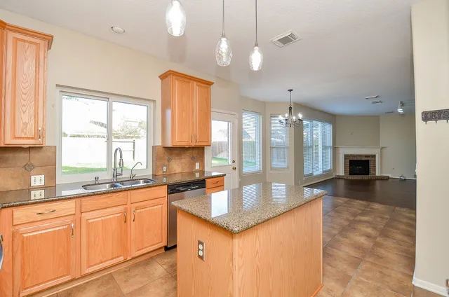 a large kitchen with kitchen island granite countertop a large window in it