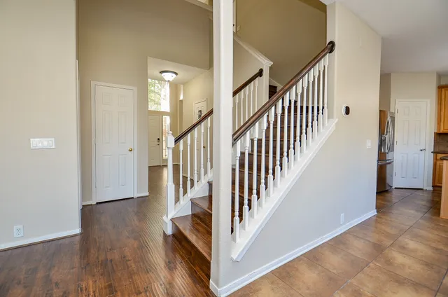 a view of a hallway with wooden floor and staircase