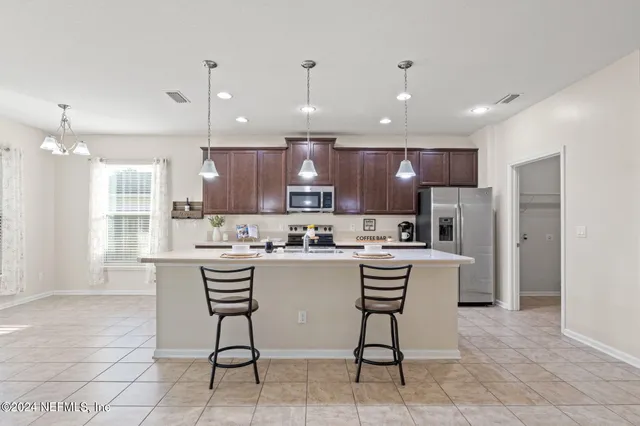 a kitchen with a refrigerator a counter top space appliances and a cabinets