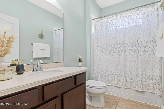 a bathroom with a granite countertop sink a toilet and a mirror