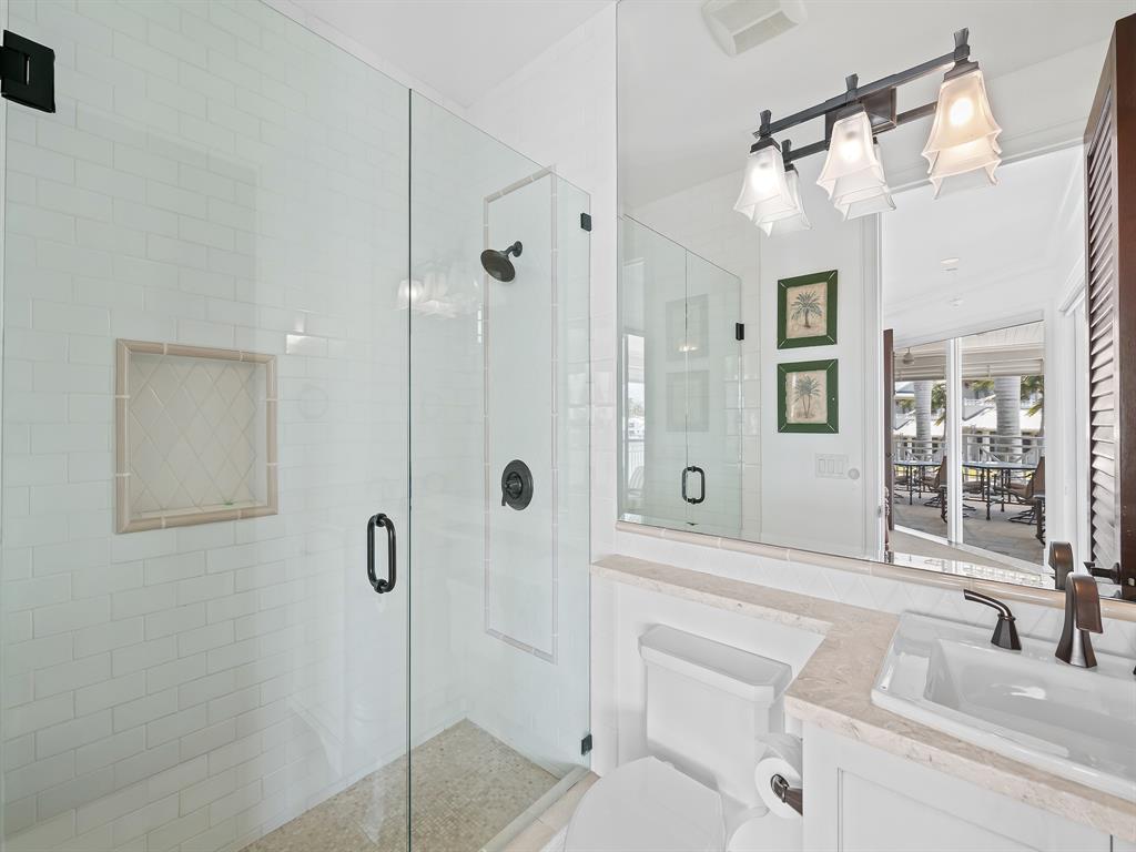 2898 Northeast 26th Street Fort Lauderdale, FL 33305 - Photo 48 of 77 a bathroom with a sink a toilet a mirror and shower