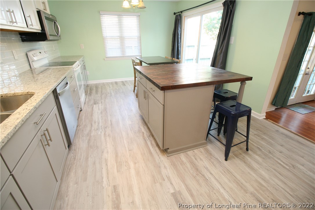 6241 Stoney Point Loop Fayetteville, NC 28306 - Photo 15 of 40 a view of a kitchen area with furniture and wooden floor