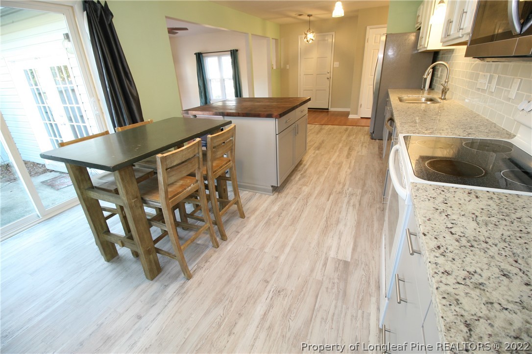 6241 Stoney Point Loop Fayetteville, NC 28306 - Photo 18 of 40 a kitchen with a sink and wooden floor