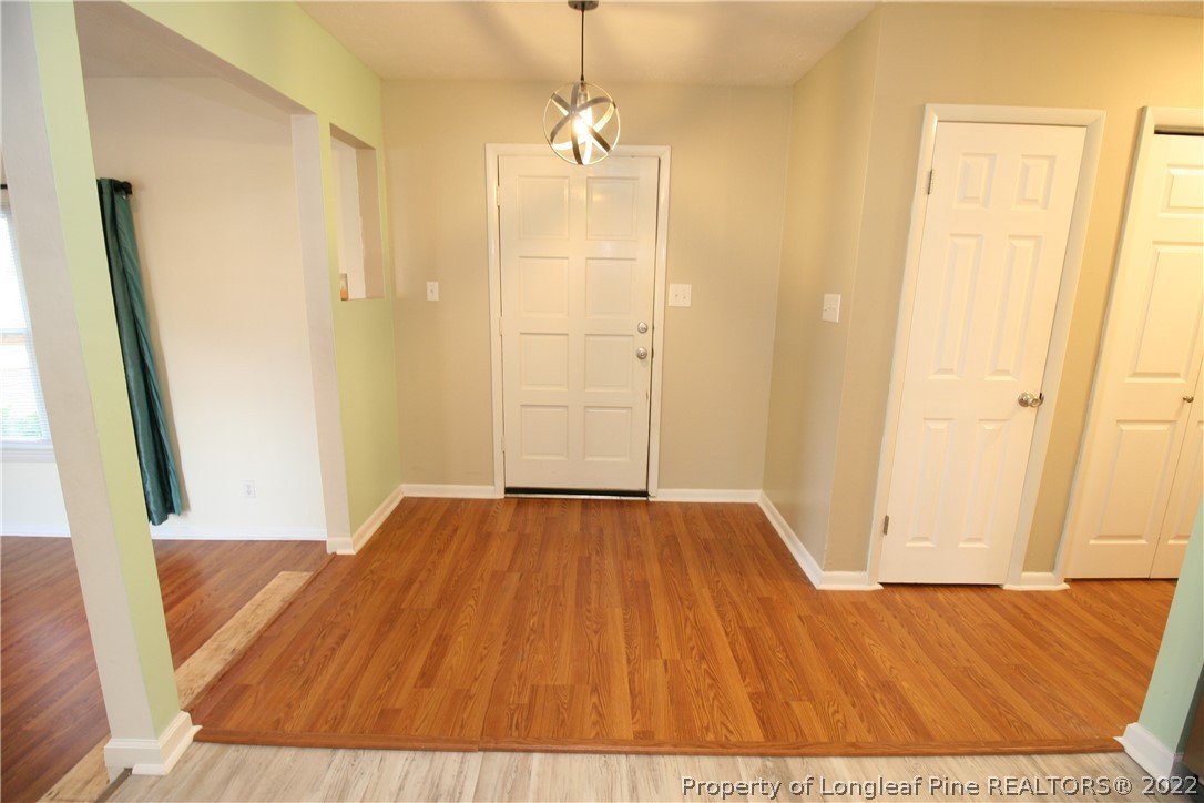 6241 Stoney Point Loop Fayetteville, NC 28306 - Photo 5 of 40 a view of a hallway with wooden floor and a bathroom