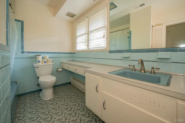 a view of an empty room with a fireplace and a window