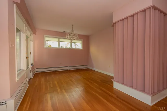 a view of a room with wooden floor and a window