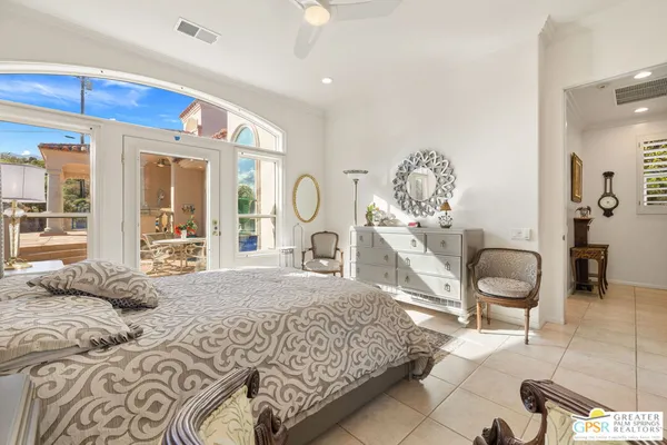 a bedroom with a large bed and a chair