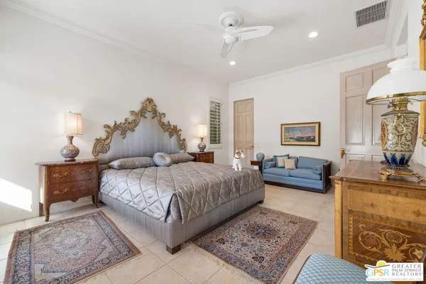 a spacious bedroom with a bed a couch and dresser
