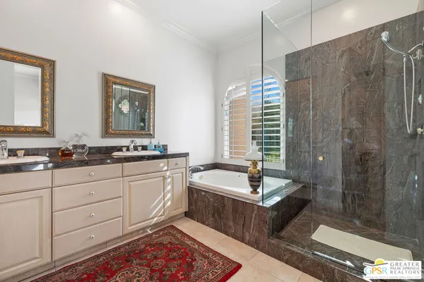 a bathroom with double vanity sinks a shower a mirror and vanity
