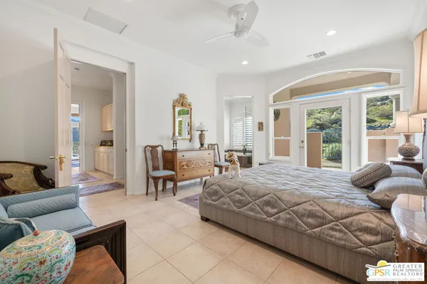 a bedroom with a bed couches and a dining table with view of kitchen