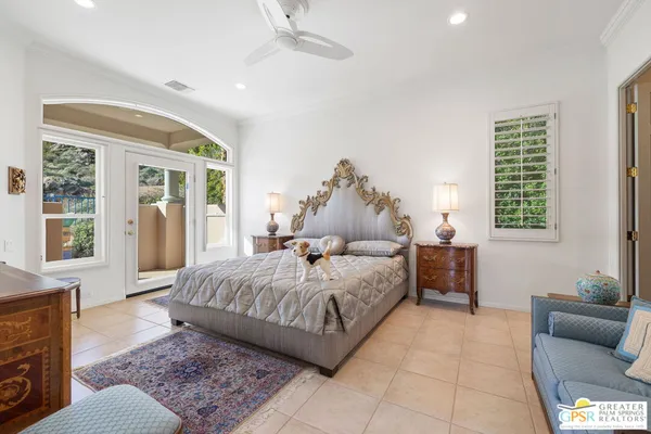 a bedroom with a large bed couch and a window