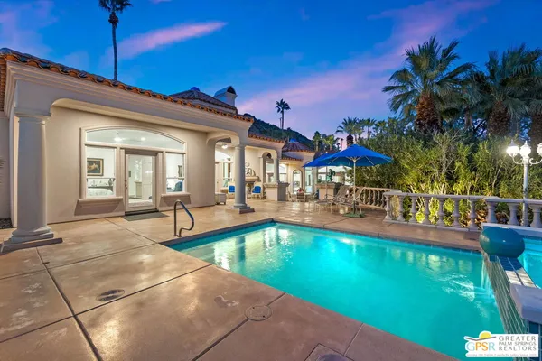a view of a house with swimming pool and sitting area