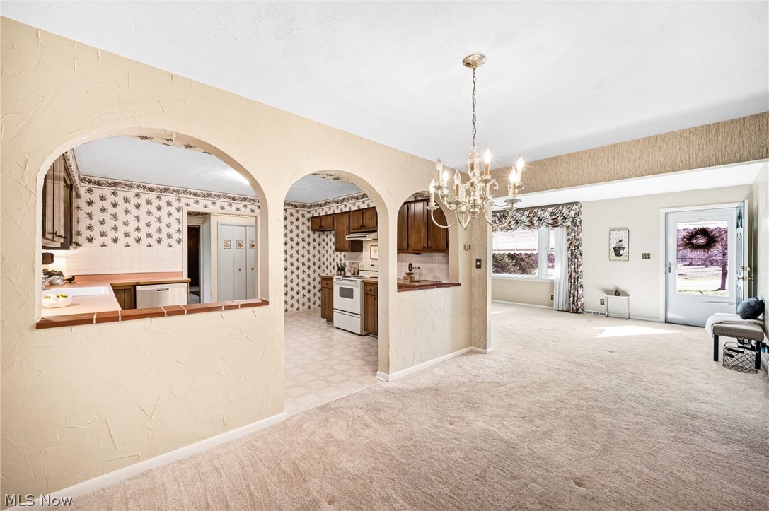 6452 Carsten Road Medina, OH 44256 - Photo 7 of 41 Unfurnished dining area with light colored carpet, a chandelier, and sink