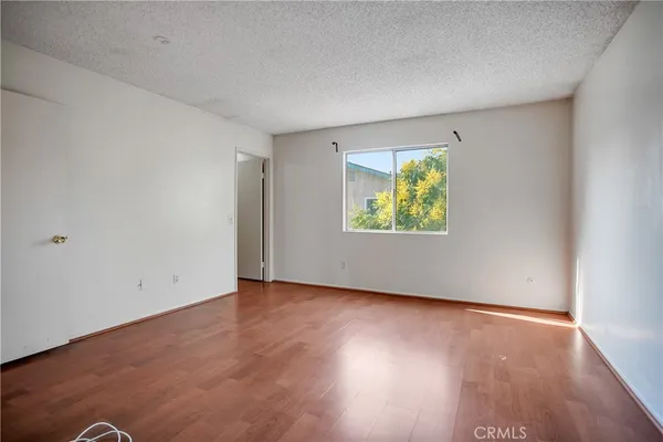 an empty room with window and wooden floor