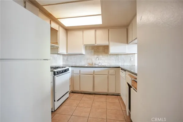 a kitchen with stainless steel appliances granite countertop a sink and a refrigerator