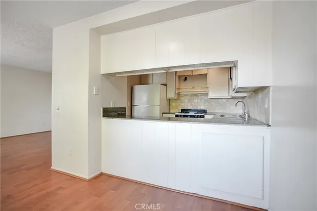 a kitchen with a refrigerator and a stove top oven