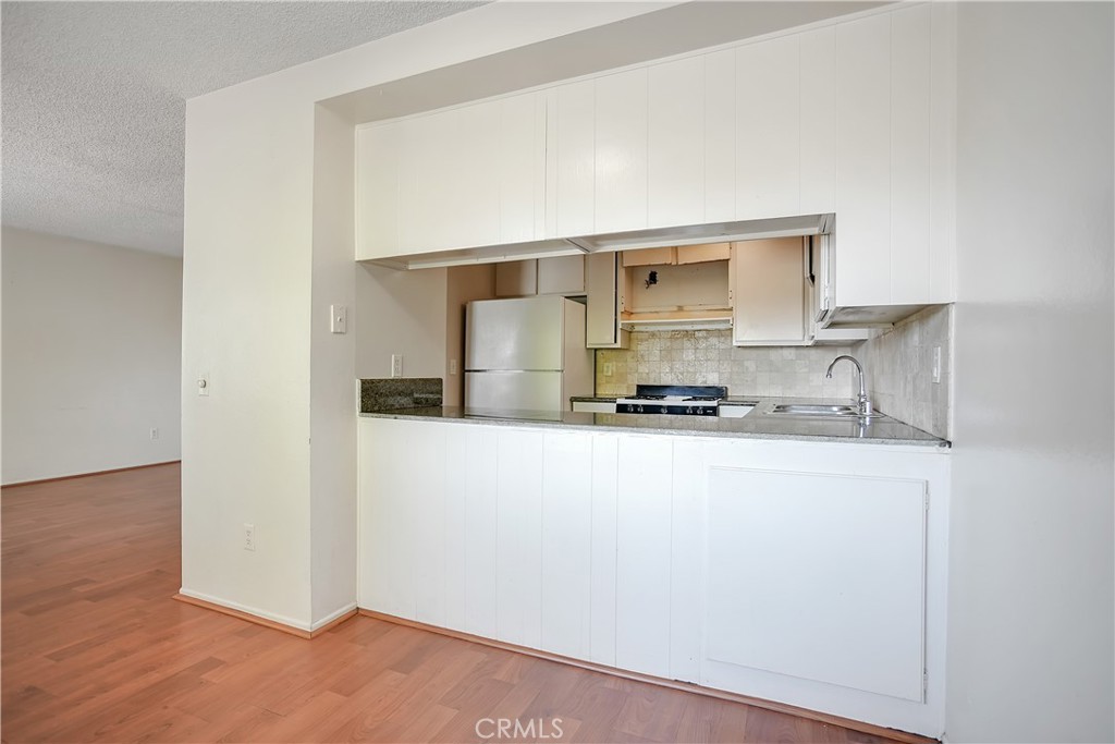 2321 Gonzaga Lane Riverside, CA 92507 - Photo 6 of 24 a kitchen with a refrigerator and a stove top oven