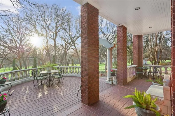 a view of a patio with a dining table and chairs with wooden floor and fence