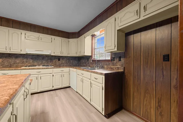 a kitchen with granite countertop wooden cabinets and white appliances