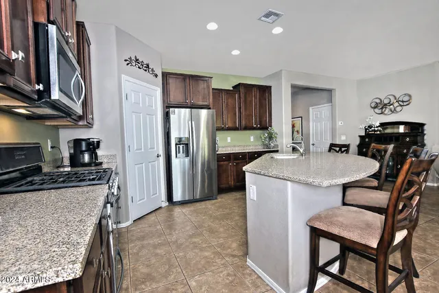 a kitchen with kitchen island a refrigerator stove and sink