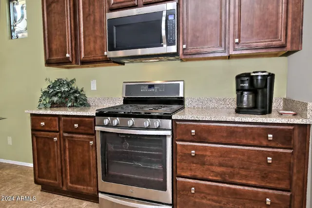 a kitchen with wooden cabinets and a stove top oven